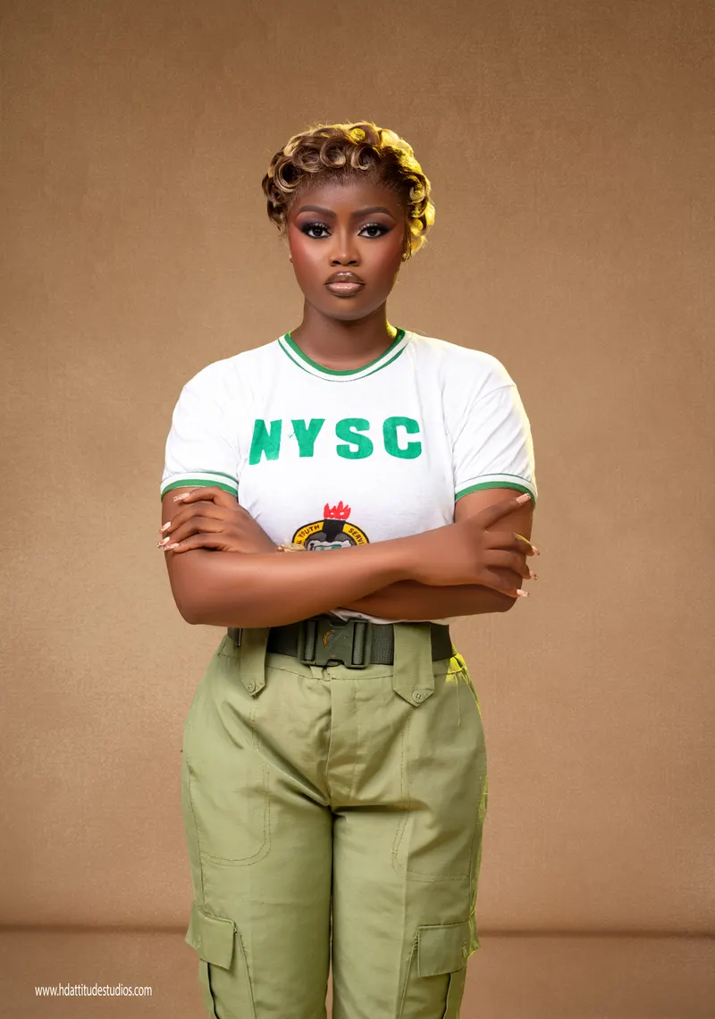 Same NYSC set, close-up arms-crossed portrait